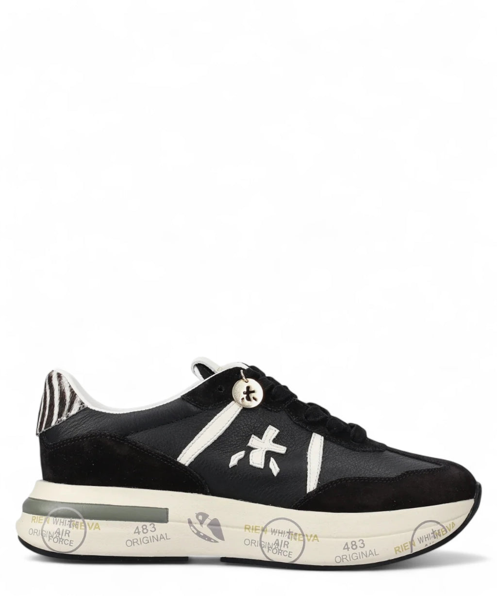 Sneakers Cassie 7681 bianche nere Premiata con dettagli zebrati sul tallone e suola con scritte, lato esterno visibile. Scarpe donna FW26.