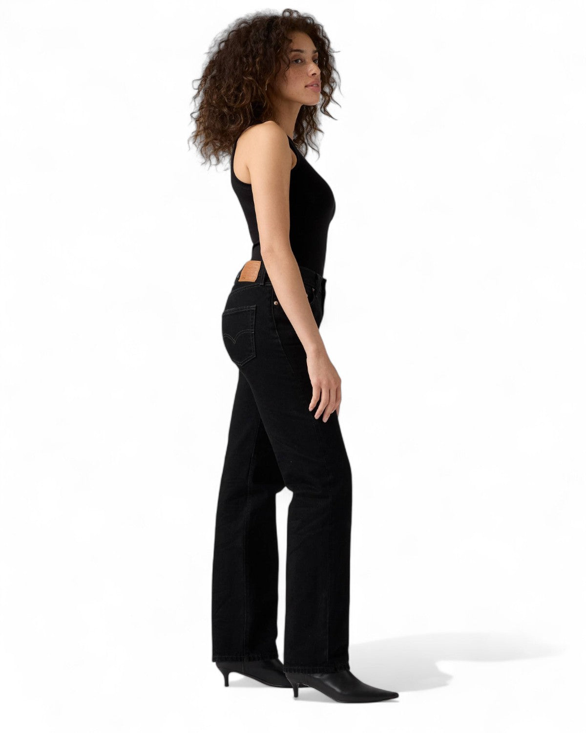 Profilo laterale di jeans Levi's 501 anni '90 da donna, stile vintage con denim nero resistente e vestibilità comoda.