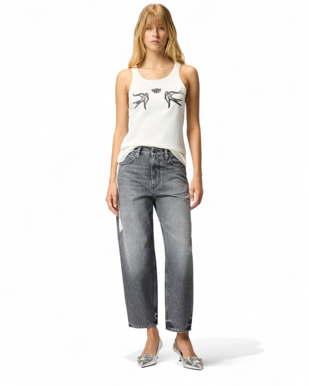 Modella indossa Jeans Balloon Love Birds in denim grigio con top bianco, look casual chic perfetto per la stagione invernale FW26.