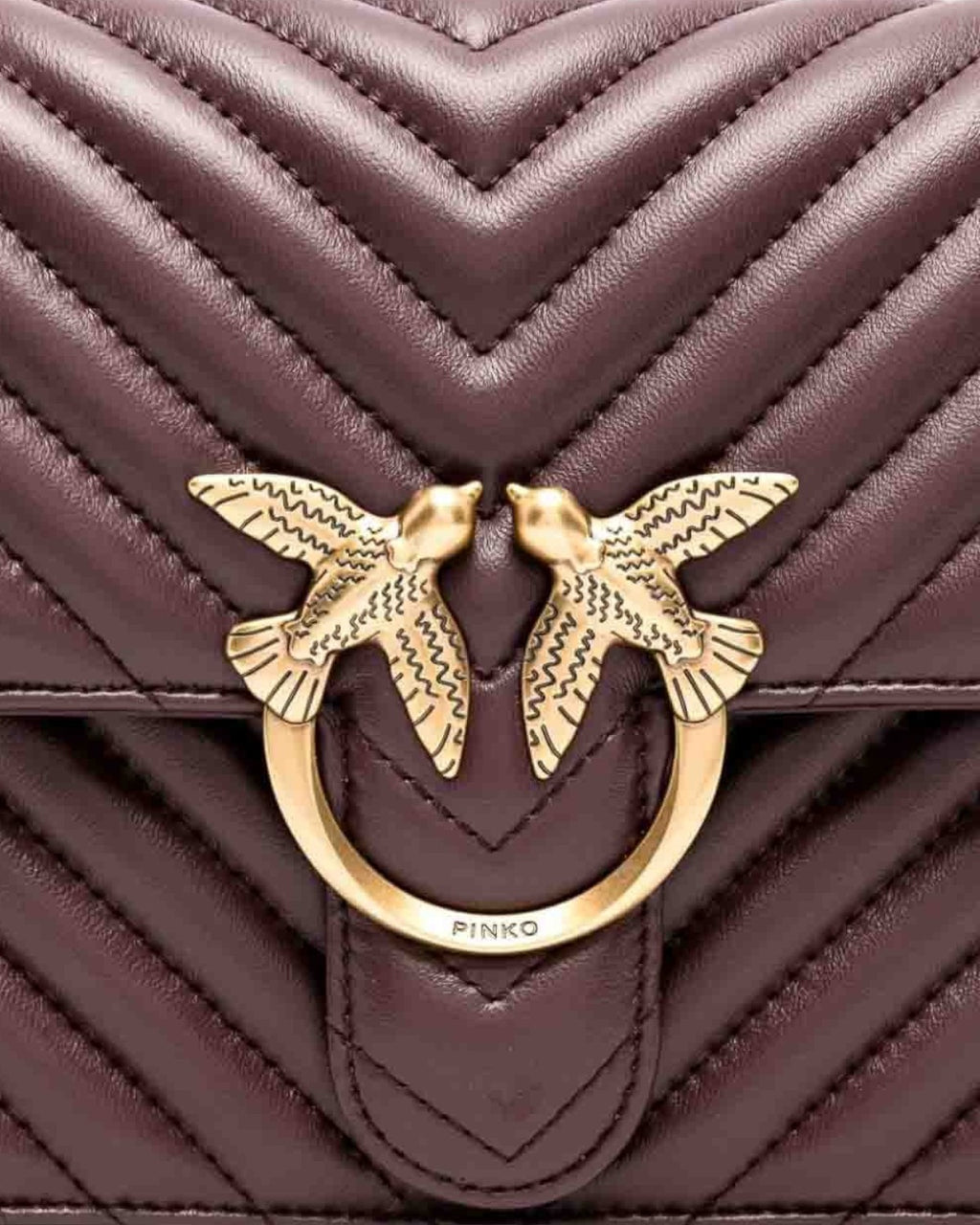 Dettaglio della fibbia Love Birds dorata sulla Love Bag Pinko in nappa matelassé chevron. Iconico elemento decorativo del brand.