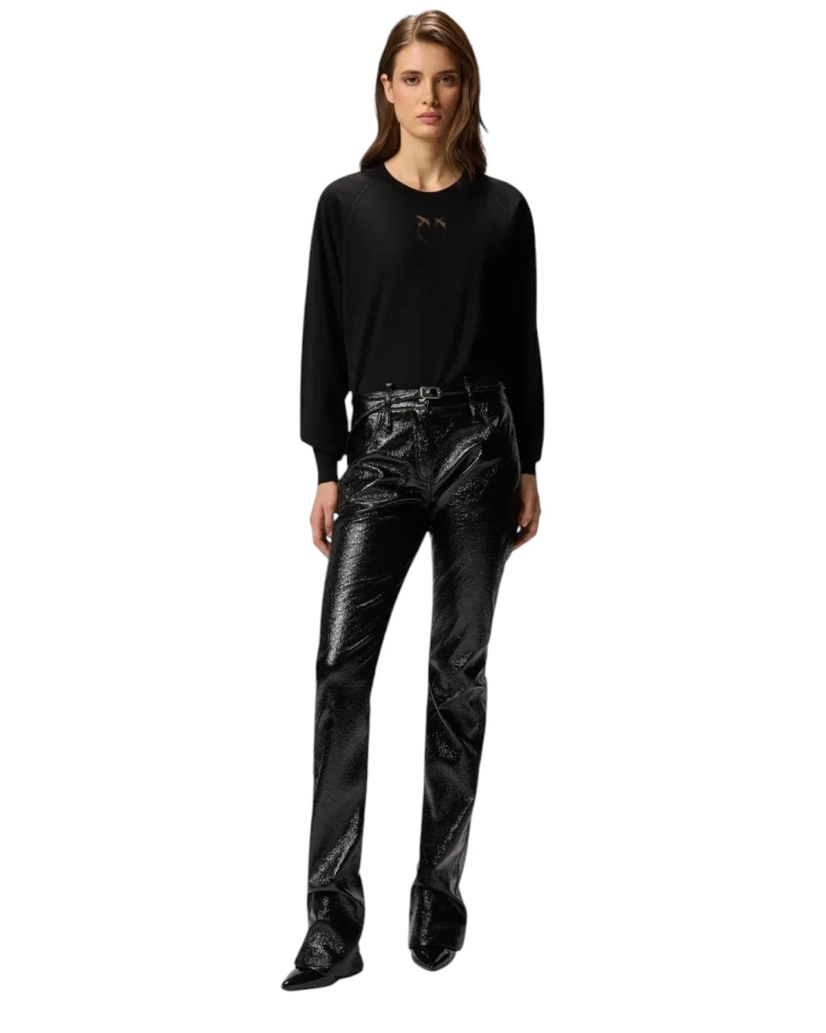 Modella indossa la Maglia Lana Merino Love Birds Dévoré Pinko abbinata a pantaloni neri lucidi, look chic e moderno per la stagione FW26.