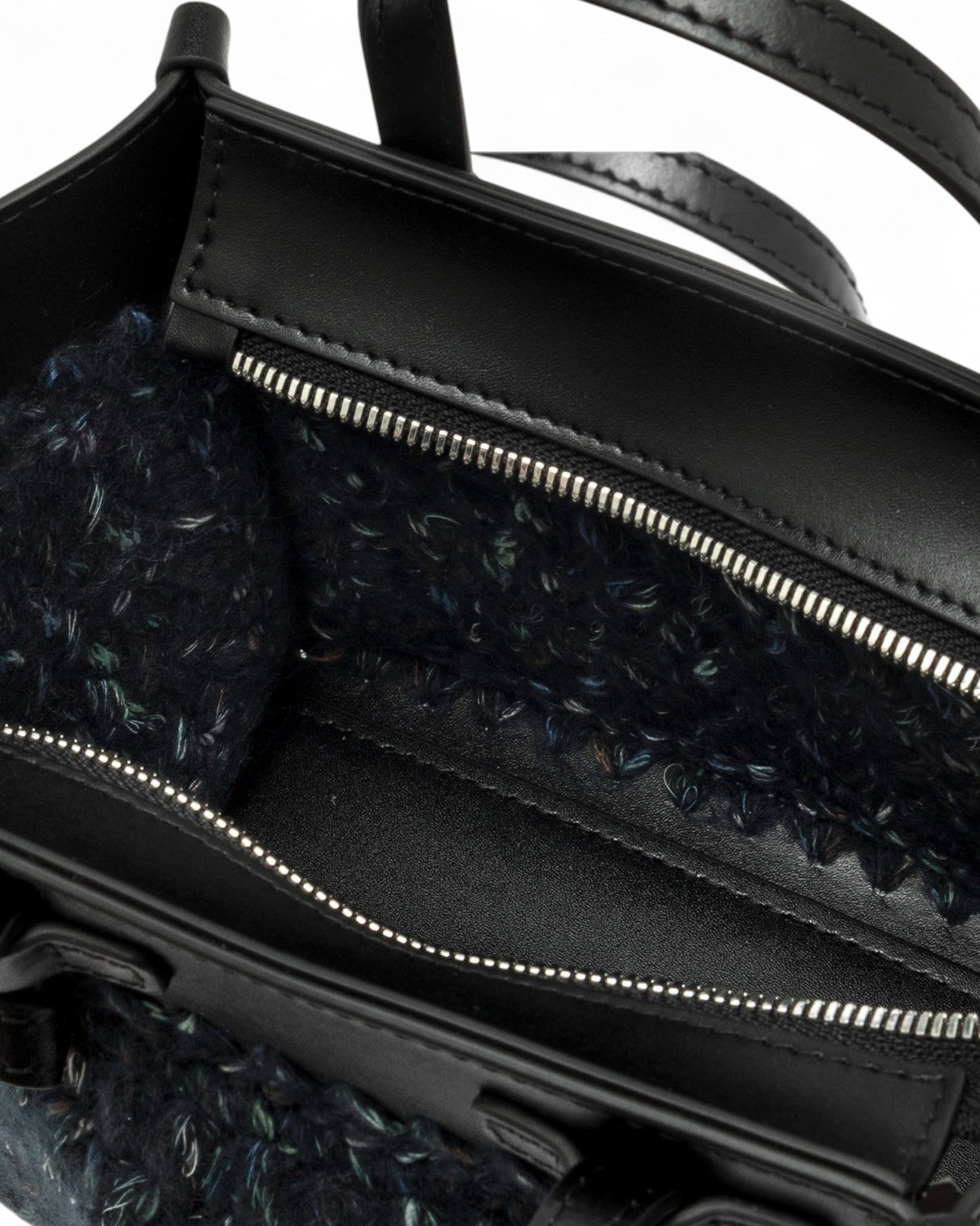 Dettaglio interno della borsa Miss Marcella Gianni Chiarini con chiusura a zip e fodera in lana intrecciata, finiture in pelle nera.